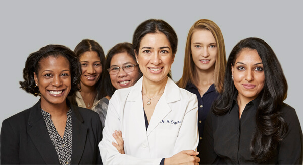 Dentist NYC - Dr. Sachar with her team of dental assistants and administrative staff all smiling at Sachar Dental